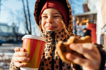 Cute girl with takeaway beverage on winter day