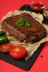 Concept of tasty food with beef steak on red background