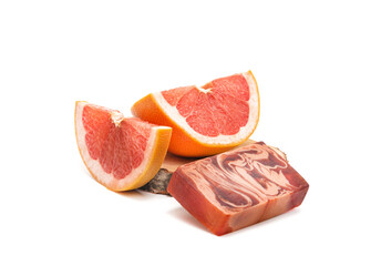 Grapefruit slices and a bar of red natural soap on a white background. Isolated. Natural cosmetics concept