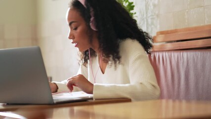 Confident African woman learning in cafe
