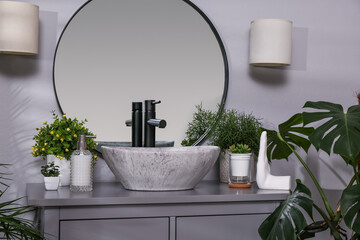 Stylish sink and beautiful green houseplants in bathroom. Interior design