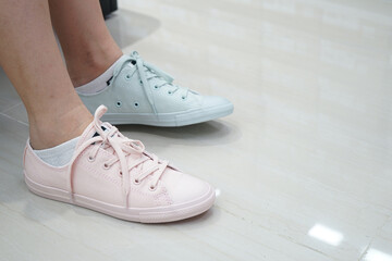 gal tries pastel sneakers pastel shade and colour in sports and fashion shoe shop.