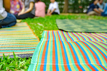 Asian mat on the grass ground in the outdoor park with blur people.