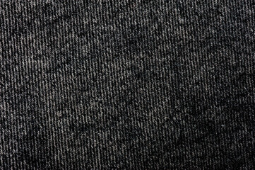 Close-up shot of black denim texture with stitching.