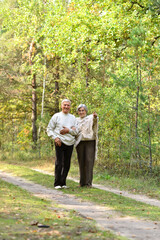 Portrait of senior couple walking in autumn forest