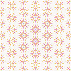 Seamless pattern of yellow and pink spikey mandala shapes on an off white background.
