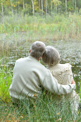 Fototapeta premium Portrait of senior couple resating near lake in autumn