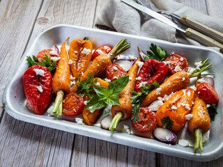 baked grill carrots, tomato, bell pepper in a plate, basil and spices vegan dish, close up, goat cheese