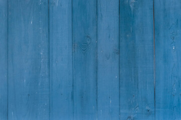 Fototapeta na wymiar Blue paint on the surface of the boards of the old fence wooden texture background