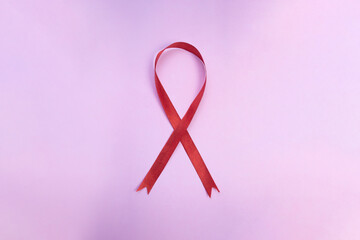 Red Ribbon for December World Aids Day (acquired immune deficiency syndrome) multiple myeloma Cancer Awareness month and National Red ribbon week. Healthcare and world cancer day on pink background