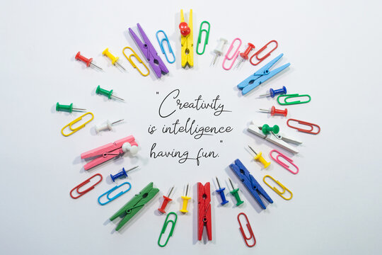 Text written creativity is intelligence having fun with office stationery clips and pins around forming a circle