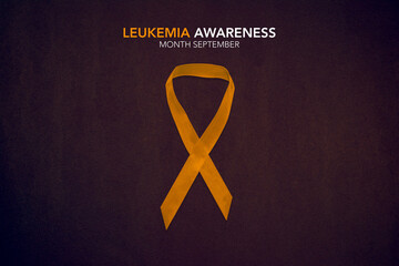 Leukemia Awareness Month. Orange Color Ribbon on brown background.
