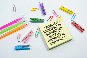 Text sign showing Never let success get to your head and never let failure get to your heart on Set of colorful paper clips with white copy space background.