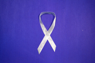 White Ribbon Campaign, of men and boys working to end male violence against women and girls, white ribbon on blue background with copy space
