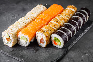 appetizing set of sushi roll on a black stone plate