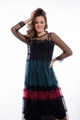 Fototapeta premium High fashion photo of a beautiful elegant young woman in a pretty triple black, red, green color dress with lace, blue shoes posing on white background. Slim figure, hair, shiny curls. Studio Shot