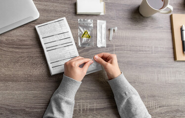 medicine, quarantine and pandemic concept - hands of woman unpacking coronavirus test kit at home © Syda Productions