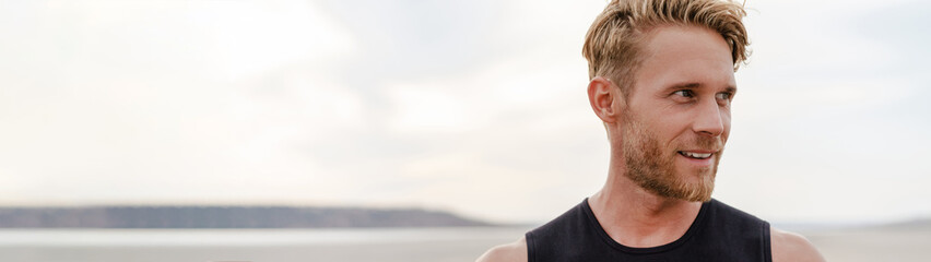 Fototapeta premium White ginger sportsman with beard smiling while working out