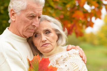 Portrait of sad senior couple in autumn park