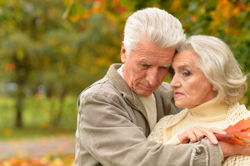 Portrait of sad senior couple in autumn park