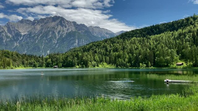 Lauter Lake in summer with stand up paddle and Karwendel mountains in the background, very close to the bavarian town of Mittenwald in Germany