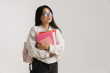 Fototapeta premium Young asian woman in eyeglasses posing with exercise books