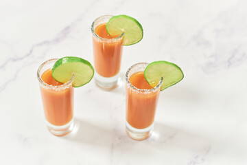 Three tequila shots with sangrita and lime on top. Mexican appetizer for tequila.
