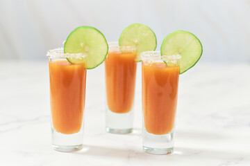 Three tequila shots with sangrita and lime on top. Mexican appetizer for tequila.