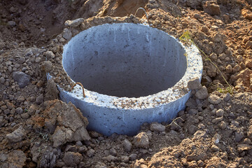 Construction of a septic tank sewer well. A concrete ring in the ground.
