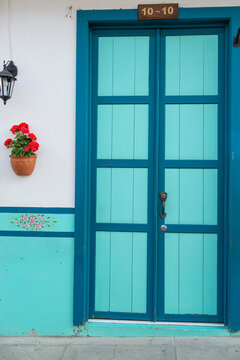 Blue door of a house in the foreground. Jardin, Antioquia, Colombia.
