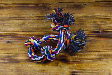 Colorful rope toy for dog on wooden background