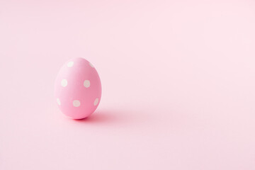 Fototapeta na wymiar Egg with white dots on pastel pink background. Easter minimal concept. Flat lay mood. Easter egg minimalism. Organic food concept. Holiday seasson.