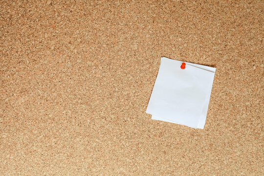Blank sheet of paper for notes pinned to cork notice board. Free space for text