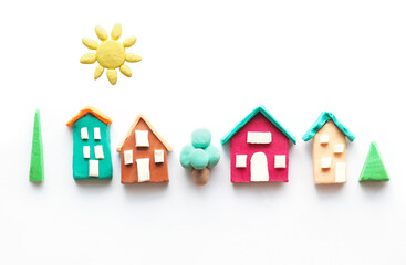 rustic multi-colored cute houses the sun and trees from plasticine. isolate on white background.