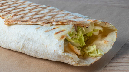 Shawarma chicken roll. Fresh roll of thin lavash or pita bread filled with grilled meat, cheese, carrots, sauce, green.
