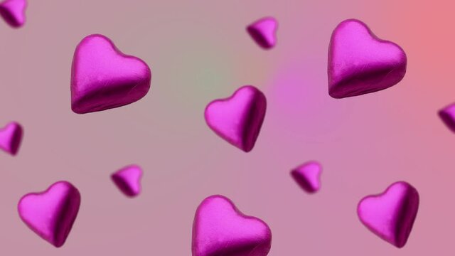 A heart shape wrapped chocolate candy flying and wiggle on a trending pink gradient animation background. Sweet food concept. Love template for mother's and valentine's day. 4k sweets footage