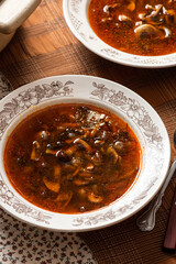 Rustic mushroom soup in a bowl on a served table.