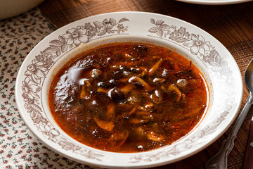 Rustic mushroom soup in a bowl on a served table.