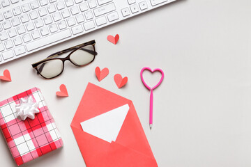 Desktop view from above. Glasses keyboard gift letter with valentine's day note on gray table
