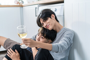 Asian handsome man gay family sit on floor, drink cup of wine together. 