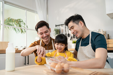Asian attractive LGBTQ gay family teach girl kid making yeast dough.