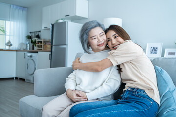 Asian lovely family, young daughter hugging and sit with older mother. 