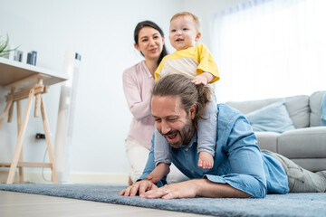 Caucasian happy loving parent play with baby toddler in living room. 