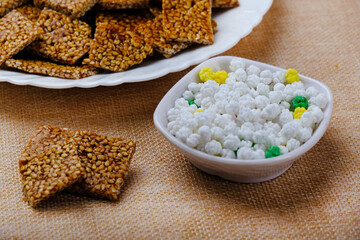 Makar sankranti special items Tilgul, Til ke laddu, Chikki all sweet items made with white sesame seeds and jaggery. Winter special indian food healthy seasonal.