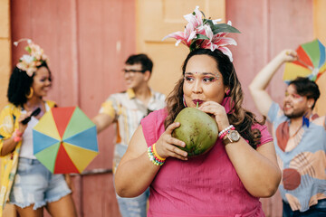 Brazilian Carnival. Concept of care during carnival. Woman hydrating herself drinking coconut water