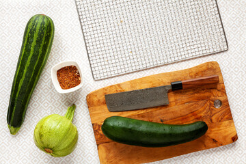 Preparing zucchini to dry. Cutting courgette vegetable and seasoning with Ethiopian berber spice...