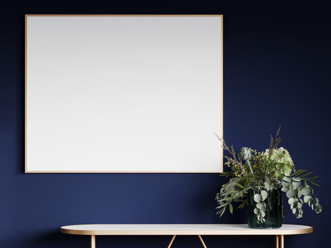 A thin gold frame with a mock-up for a painting on a dark blue navy wall. Gold console with white top and a large bouquet of flowers. Horizontal painting in luxury style. 3d rendering