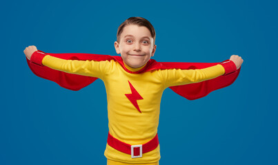 Funny boy in superhero cape in studio © kegfire