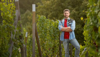 vineyard owner standing at winery among grape farm, copy space, winemaker