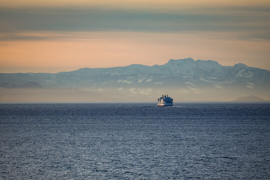 ferry or ship at sunset crossing the waters of the Salish Sea with Vancouver Island in the background